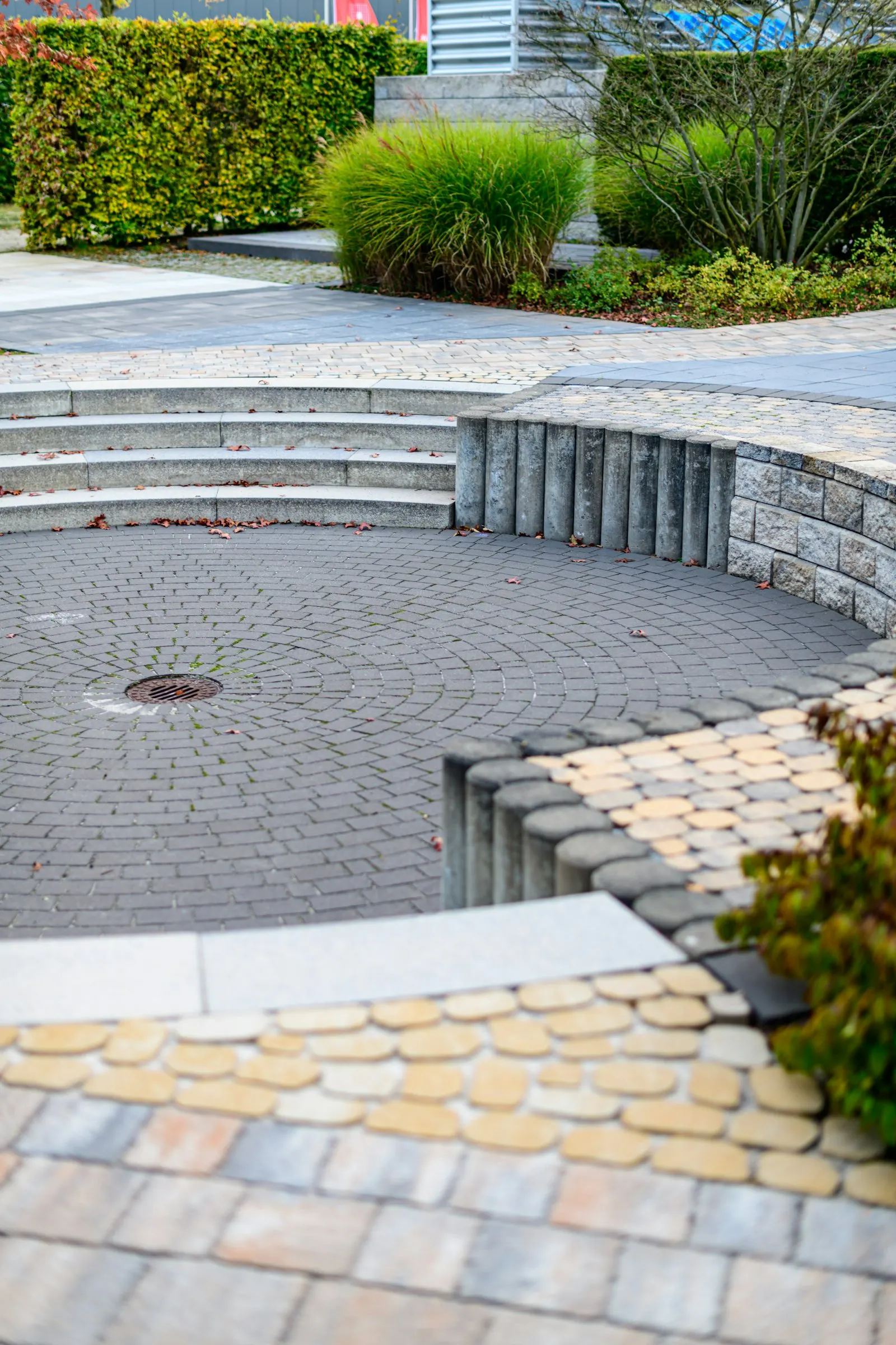 Curved paver seat wall edging a planted bed in a backyard install