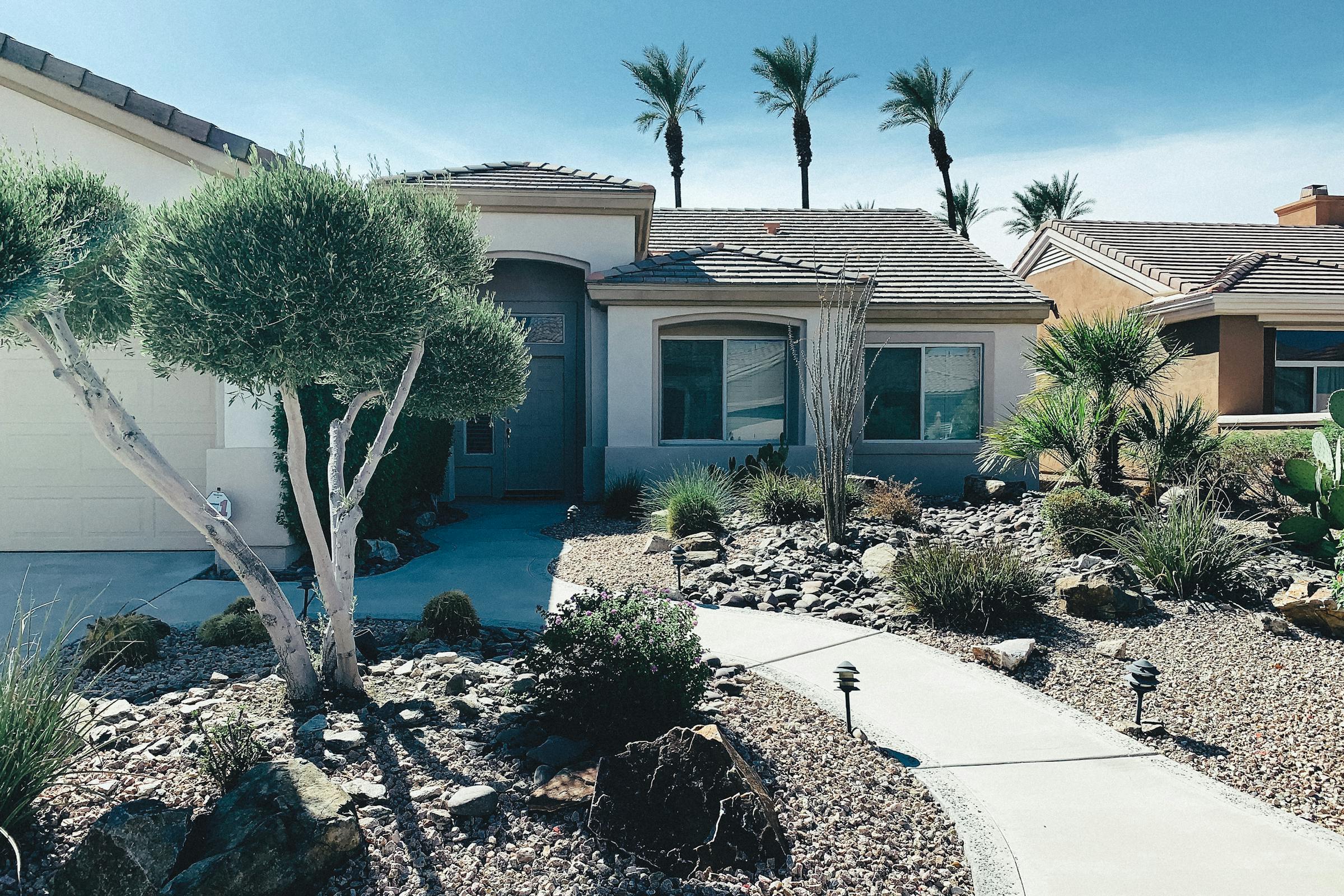 Xeriscape front yard with palms and DG, Sonoran exurb home